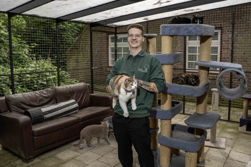Jelle van den Munckhof met Storm (op de grond), Pumba (in zijn armen) en van bovenaf: Tomtom en Chill in het buitenverblijf